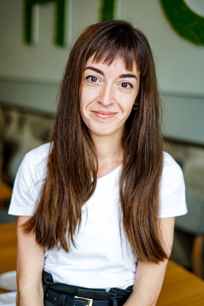 Gastgeberin Clara Cotés Zarabozo vor HYG Logo im Restaurant